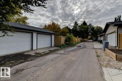 Detached two-stall garage with white panel doors and shingle roofing - 