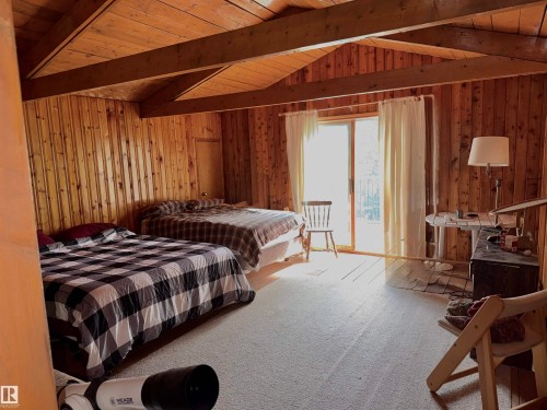 Vaulted wood-paneled ceilings with exposed beams - 208 60118 Secondary Highway 867, Rural St. Paul County, AB - Indoor Photo Showing Bedroom