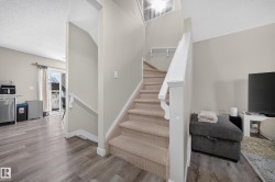 Carpeted staircase with white railing leading to an upper level - 