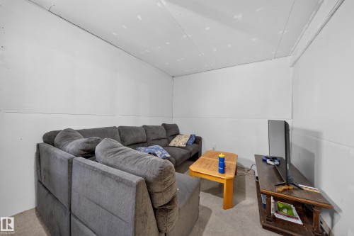Finished basement room with white paneled walls and a light-colored carpet - 59 2503 24 Street, Edmonton, AB 