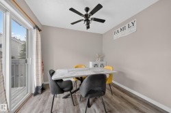 Dining area featuring wood-finish flooring and a contemporary ceiling fan - 