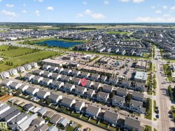 Aerial perspective showcasing a residential development with a prominent blue retention pond - 