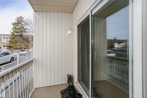 Private balcony with white vertical siding and a sliding glass door - 204 11440 40 Ave, Edmonton, AB 