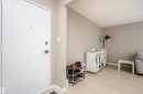 Entryway featuring a white door with dark hardware, light wood-finish flooring, and neutral-toned walls - 204 11440 40 Ave, Edmonton, AB 