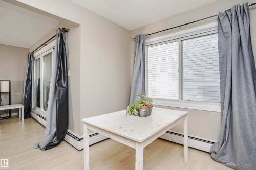 Light-toned wood-finish flooring complements the neutral wall color - 204 11440 40 Ave, Edmonton, AB 