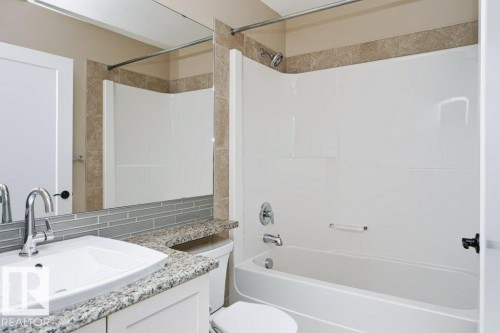 Bathroom featuring a white vanity with a granite countertop, vessel sink, and chrome faucet - 27 4205 30 Street, Edmonton, AB 