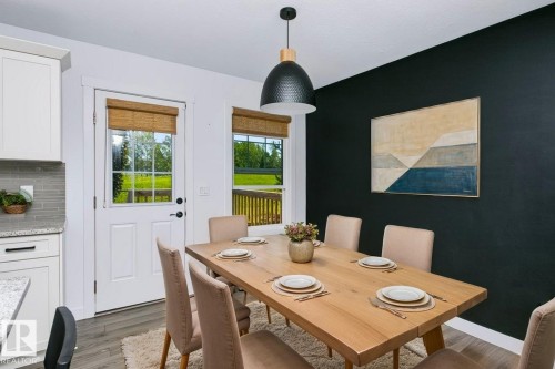 Dining area featuring a wood-finish dining table and a contrasting accent wall - 27 4205 30 Street, Edmonton, AB 
