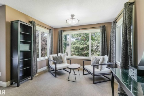 Carpeted room with multiple large windows framed by patterned drapes - 1231 Tredger Crest, Edmonton, AB 