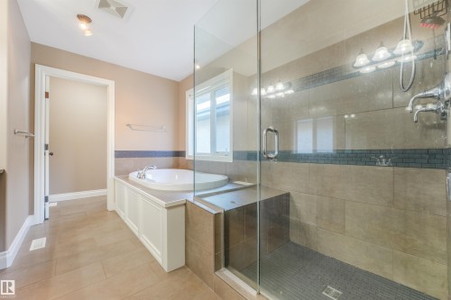 Spacious bathroom featuring a built-in soaking tub, a separate glass-enclosed shower, and tile flooring - 1231 Tredger Crest, Edmonton, AB 