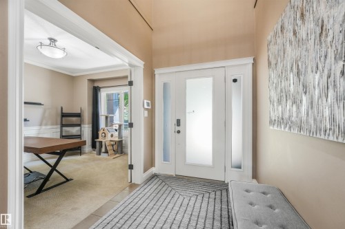 Entryway featuring a double white door with frosted glass panels and a sidelight, neutral wall tones, and a durable tile flooring transition - 1231 Tredger Crest, Edmonton, AB 