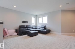 Spacious room featuring light gray walls, white trim, recessed lighting, and two windows providing natural light - 