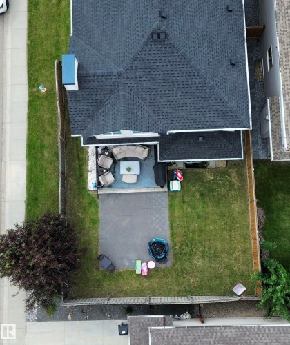 Spacious backyard featuring a large patio area with paver stones and a substantial lawn - 1304 Ainslie Wynd, Edmonton, AB 