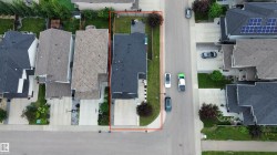 Single-family home featuring a dark shingle roof, concrete driveway, and a fenced backyard with a green lawn - 