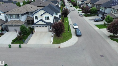 Two-story stucco and siding exterior with a dark shingle roof - 1304 Ainslie Wynd, Edmonton, AB 