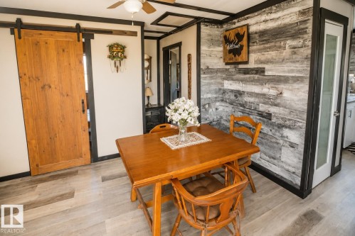 Room featuring light-toned walls, contrasting dark trim, a window with blinds, and light wood-finish flooring - 315 57201 Rng Rd 102, Rural St. Paul County, AB 