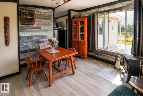 Vaulted wood-paneled ceiling with exposed beams, multiple windows, and a glass-paned exterior door - 315 57201 Rng Rd 102, Rural St. Paul County, AB 