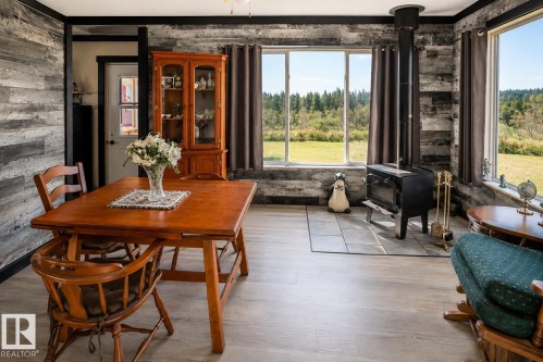 Red paneling with black trim, concrete flooring, two windows, two white doors, and a ceiling fan - 315 57201 Rng Rd 102, Rural St. Paul County, AB 