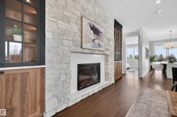 Stone-clad fireplace with an electric insert and white mantel - 