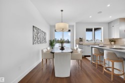 Open-concept dining area with wood-finish flooring, a contemporary drum pendant light, and direct access to an outdoor area - 
