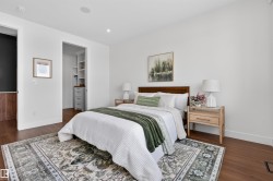 Bedroom featuring wood-finish flooring, white walls, and a recessed lighting system - 