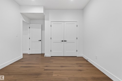 Spacious interior room featuring wood-finish flooring, white walls, and bright white trim - 149 Eastgate Way, St. Albert, AB 