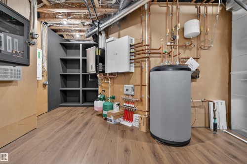 Utility room featuring wood-finish flooring, built-in shelving, and exposed ceiling joists - 149 Eastgate Way, St. Albert, AB 