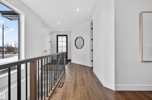 Upper hallway featuring wood-finish flooring, white walls, and recessed lighting - 149 Eastgate Way, St. Albert, AB 
