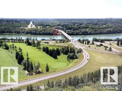 Expansive green space featuring a golf course, mature trees, and a river with a bridge - 1805 10011 123 Street, Edmonton, AB 