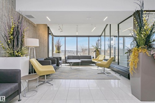 Lobby area featuring full-height windows, white tile flooring, and a contemporary ceiling design with recessed lighting - 1805 10011 123 Street, Edmonton, AB 
