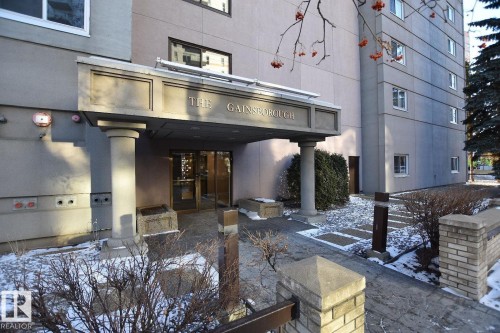 "The Gainsborough" building entrance featuring a covered portico, decorative columns, and a stone walkway - 1805 10011 123 Street, Edmonton, AB 