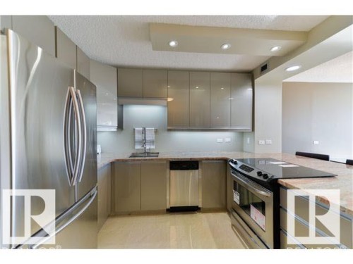 Modern kitchen featuring stainless steel appliances, flat-panel cabinetry, granite-finish countertops, and recessed lighting - 1805 10011 123 Street, Edmonton, AB 