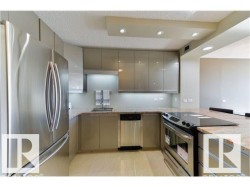 Modern kitchen featuring stainless steel appliances, flat-panel cabinetry, granite-finish countertops, and recessed lighting - 