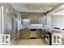 Modern kitchen featuring stainless steel appliances, flat-panel cabinetry, granite-finish countertops, and recessed lighting - 1805 10011 123 Street, Edmonton, AB 
