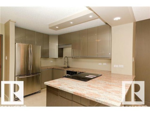 Modern kitchen featuring stainless steel appliances and an integrated cooktop - 1805 10011 123 Street, Edmonton, AB 