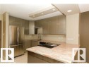 Modern kitchen featuring stainless steel appliances and an integrated cooktop - 1805 10011 123 Street, Edmonton, AB 