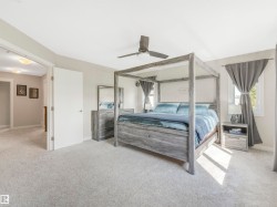 The primary bedroom features extra windows that fill the space with natural light and showcase breathtaking views of your private backyard oasis. - 