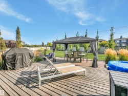 Two-level deck with a natural gas BBQ line, Hideaway privacy screens, elegant metal railings, and a lower-level aluminum gazebo. - 