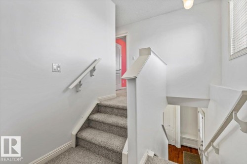 Carpeted staircase with white handrails and painted balustrades - 2407 Hagen Way, Edmonton, AB 
