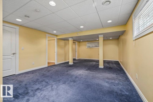 Spacious finished lower level with blue carpeting, recessed lighting, and a drop ceiling - 2407 Hagen Way, Edmonton, AB 