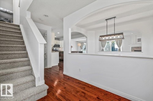 Warm wood-finish flooring complements the carpeted staircase - 2407 Hagen Way, Edmonton, AB 