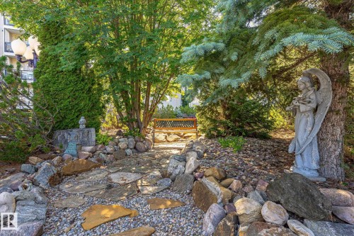 Landscaped garden pathway featuring flagstone steps and decorative river rock - #310 237 Youville Dr E Nw, Edmonton, AB - Outdoor