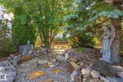 Landscaped garden pathway featuring flagstone steps and decorative river rock - 