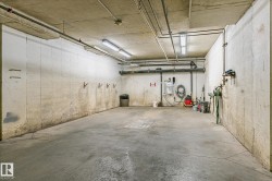 Concrete floor with a visible drainage grate, illuminated by multiple overhead fluorescent light fixtures - 