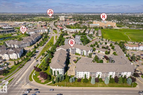 Aerial perspective showcasing a multi-building residential complex surrounded by mature landscaping and paved roadways - #310 237 Youville Dr E Nw, Edmonton, AB - Outdoor With View
