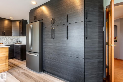 New kitchen cabinetry with a dark wood-finish, featuring streamlined hardware and integrated appliances - 114 Reichert Drive, Beaumont, AB 