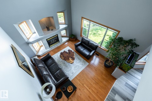 View of the living room from the stairs, featuring high ceilings and wood flooring - 114 Reichert Drive, Beaumont, AB 