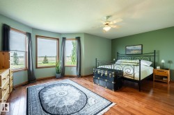 Huge bedroom with gorgeous views, including the golf course and downtown Edmonton, with hardwood flooring complementing by a bay window - 