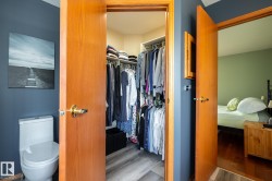Walk-in closet in the primary bedroom suite featuring wire shelving and wood-finish flooring - 