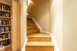 Staircase into basement featuring wood-finish treads and white risers - 