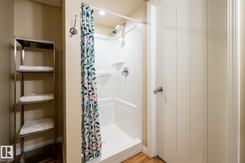 White fiberglass shower stall in the basement bathroom with integrated shelving, chrome fixtures, and recessed lighting - 114 Reichert Drive, Beaumont, AB 